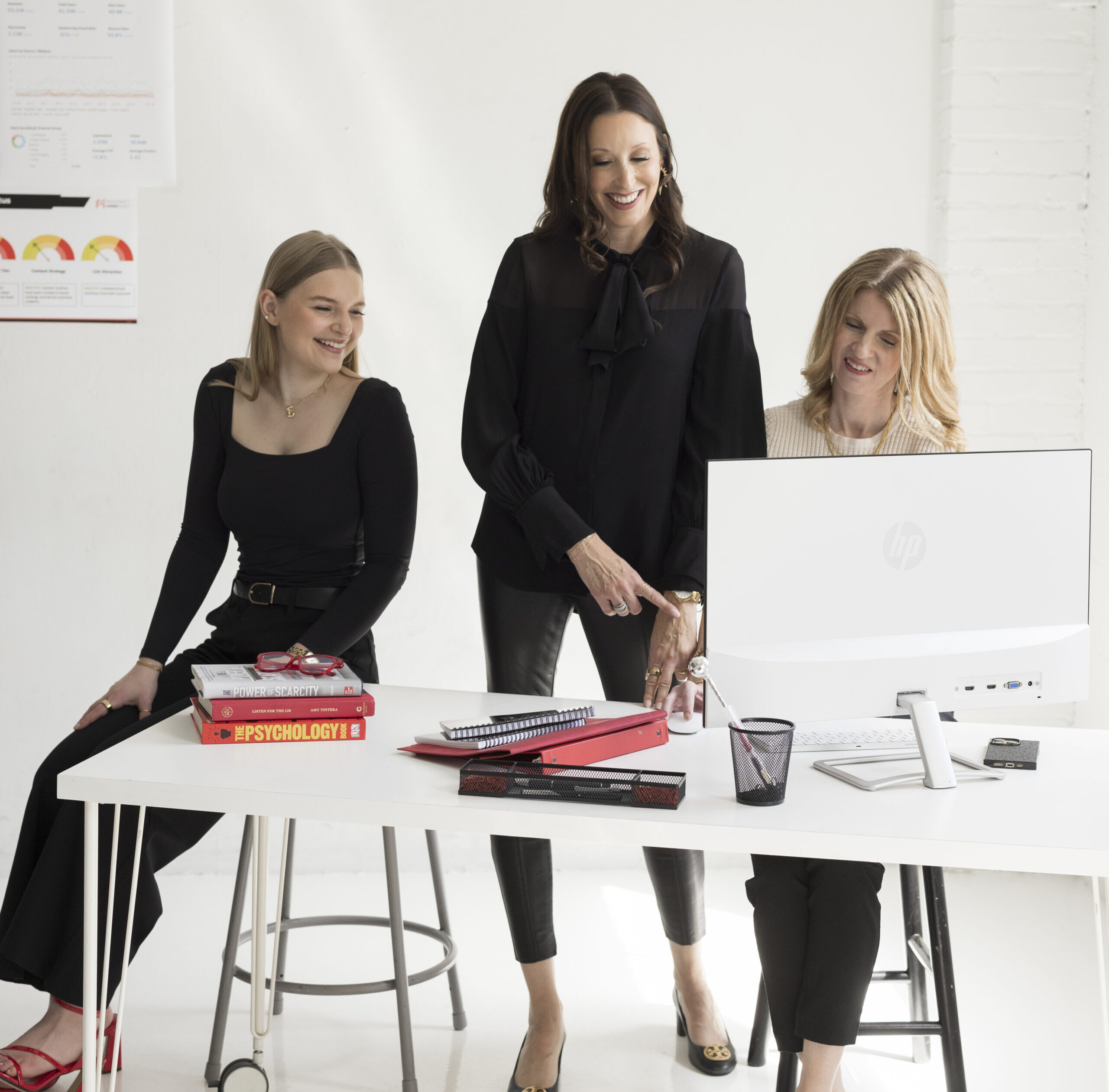three professional at a desk working on a computer