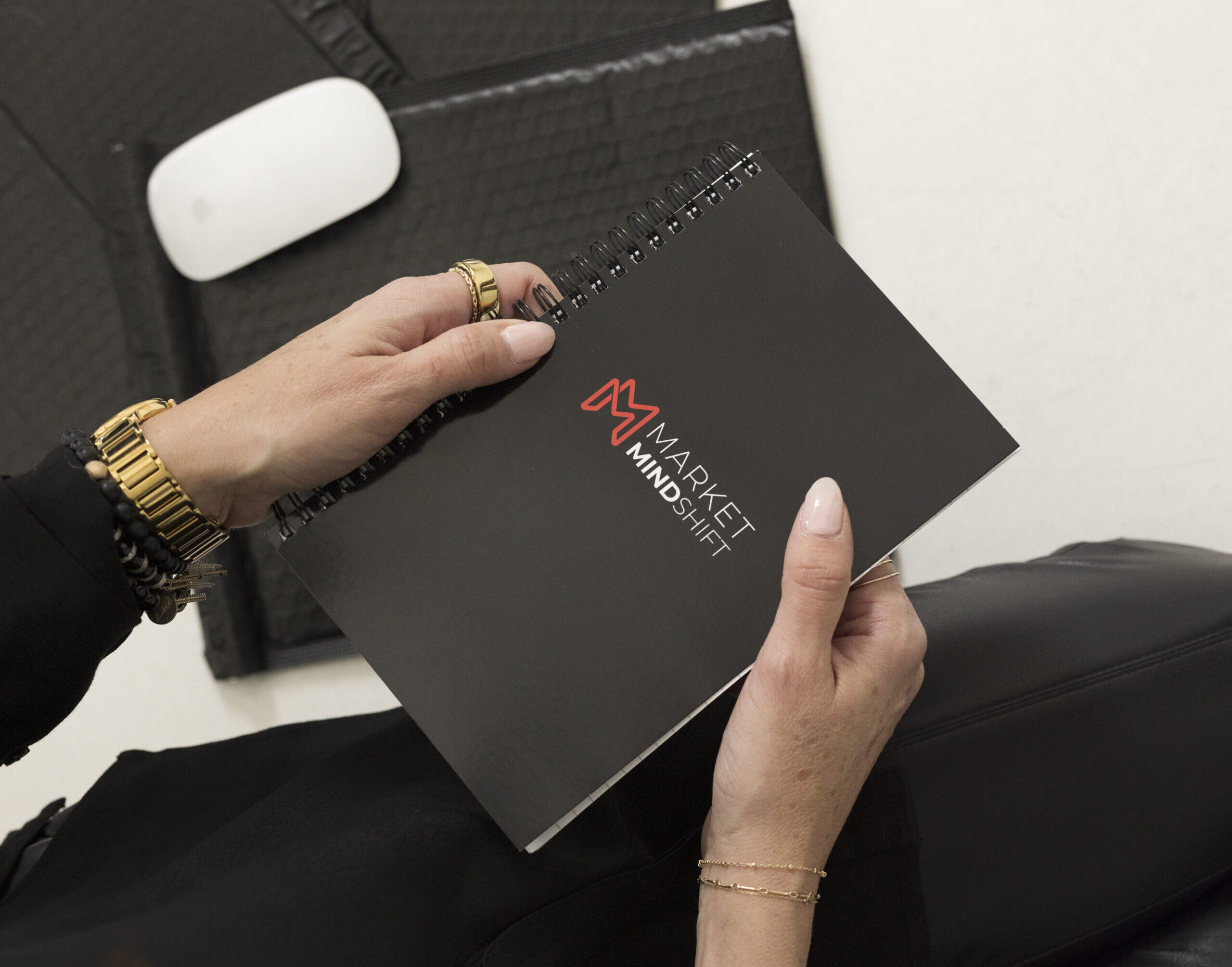 close up of a person holding a black notebook